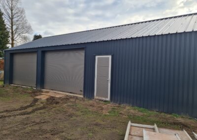 Een garage met een blauwe deur en een metalen dak.