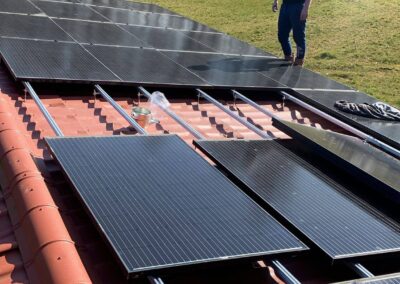 Een man op een dak met zonnepanelen.