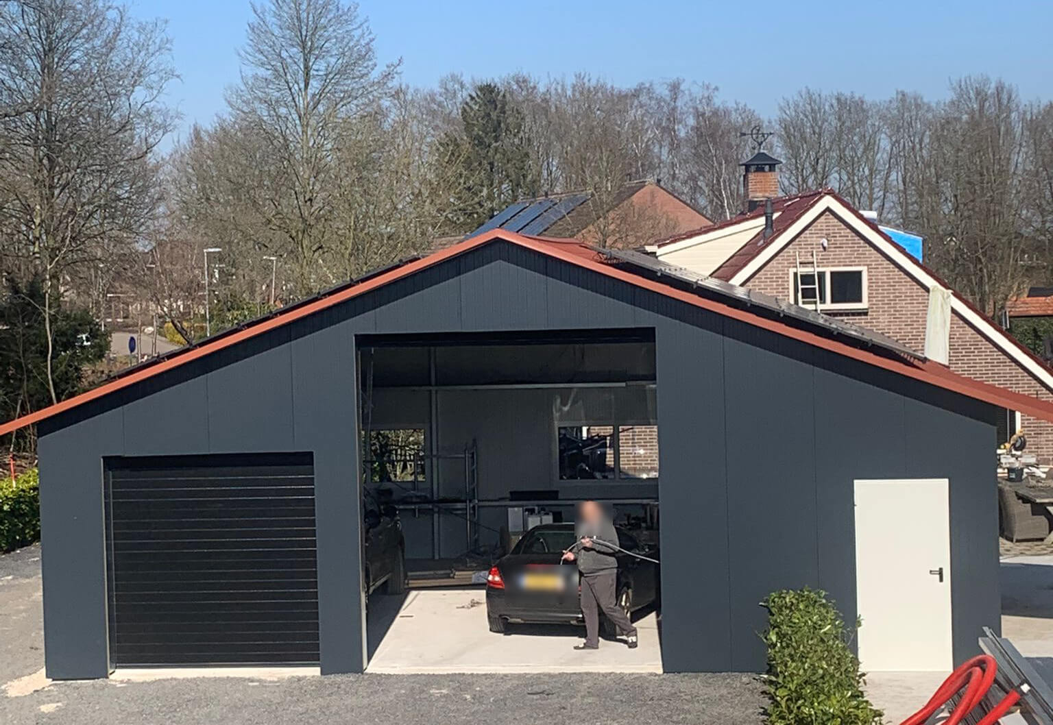 gh2 Een garage met een auto ervoor geparkeerd.