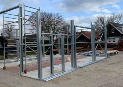 Op een parkeerplaats wordt een metalen constructie gebouwd.