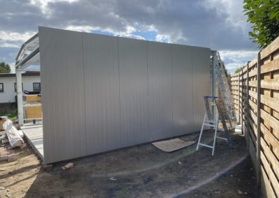 In een achtertuin wordt een schuur gebouwd als onderdeel van een project in Hoboken.