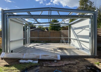 In de achtertuin wordt een metalen garage (B) gebouwd als onderdeel van de Projectpagina Hoboken.