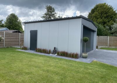 Een grijze metalen schuur in een achtertuin, te zien op de projectpagina van Hoboken.